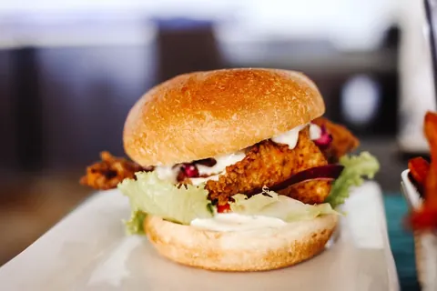 A crispy fried chicken burger with lettuce and sauce