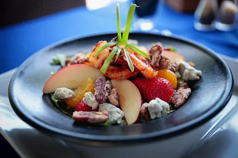 A salad with fresh fruit, nuts and cheese