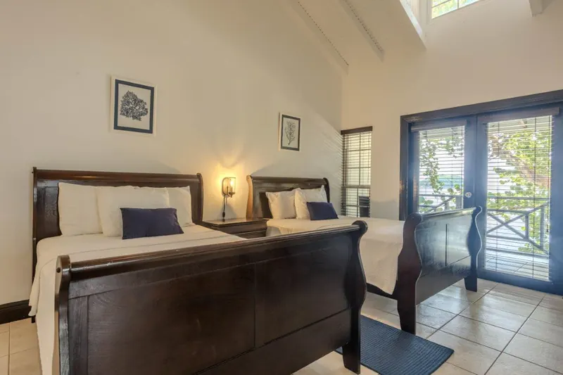 Deluxe Room with two sleigh beds and French doors to the balcony