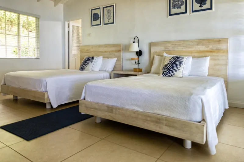 Bedroom with two beds and framed coral prints