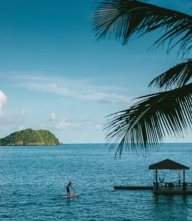 A paddleboarder on the bay beside the jetty gazebo